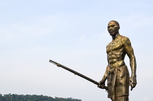 La statue en bronze de Wongo, fusil à la main, détachée sur le ciel de Lastourville